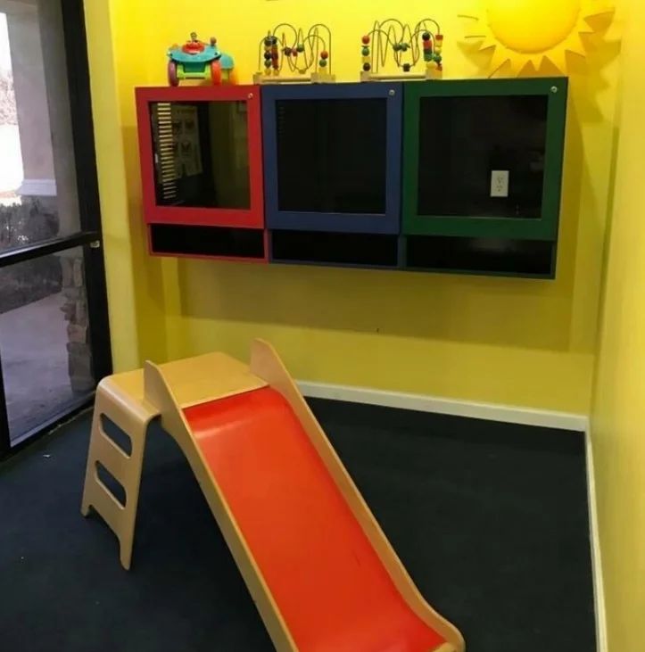 Inside the kids play room at Story Dental, with a small slide